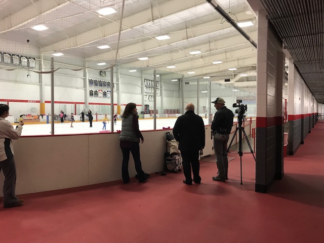 People Recording Figure Skating From Off The Ice